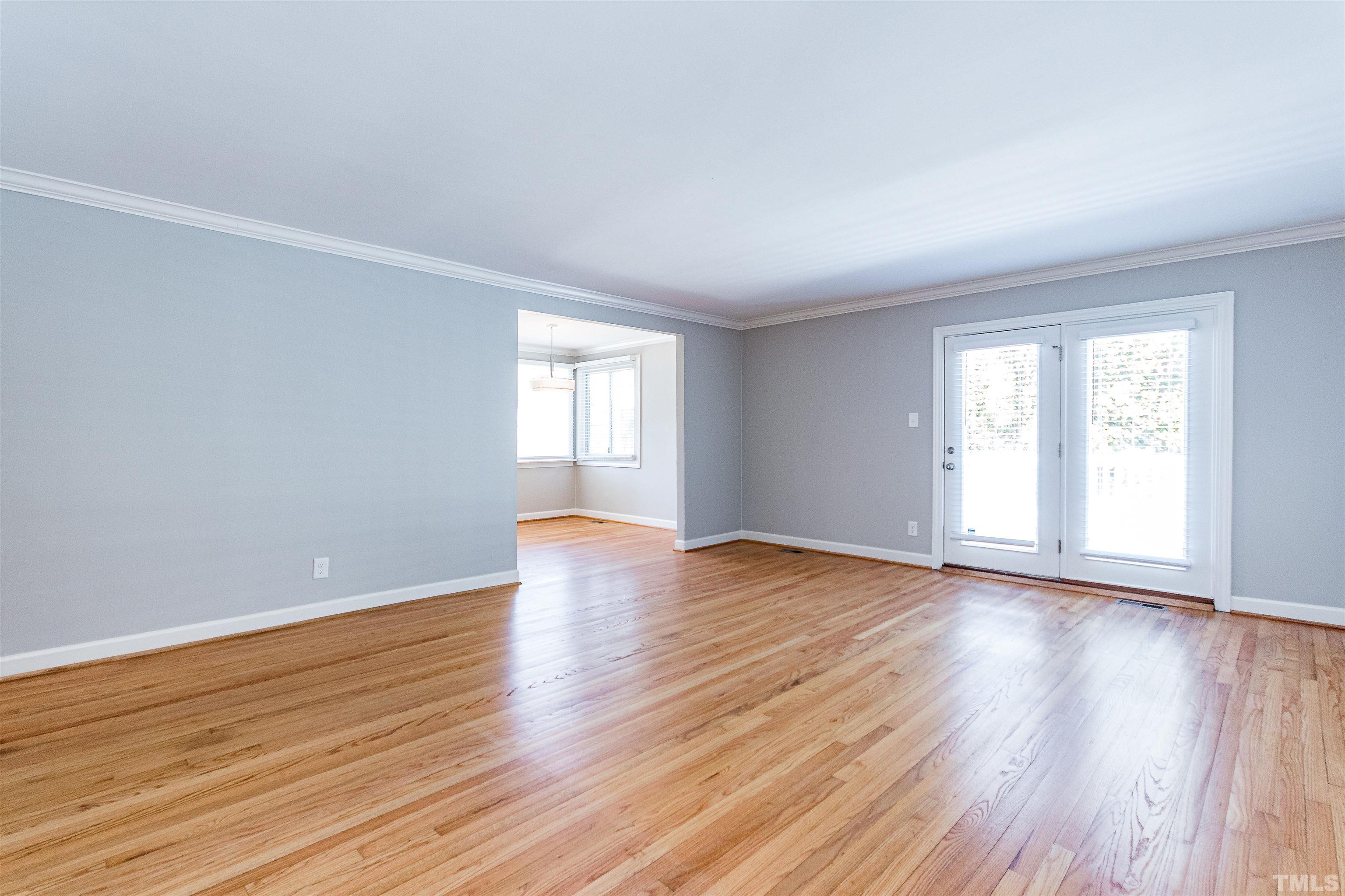 3412 Bradley Place Raleigh, NC 27607 - Photo 6 of 28 a view of an empty room with wooden floor and window