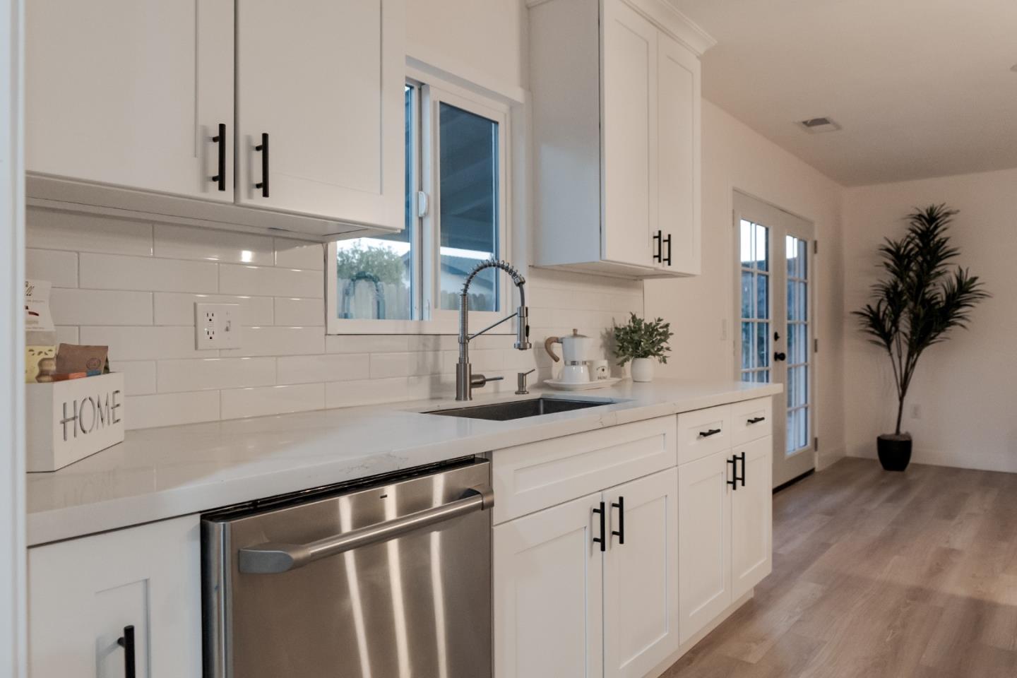 1429 Chadwick Place Manteca, CA 95336 - Photo 4 of 26 a kitchen with white cabinets a sink dishwasher and a stove with wooden floor