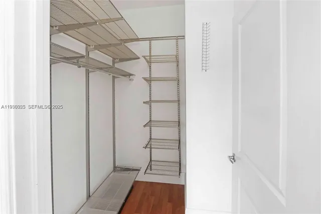 a view of walk in closet with empty racks