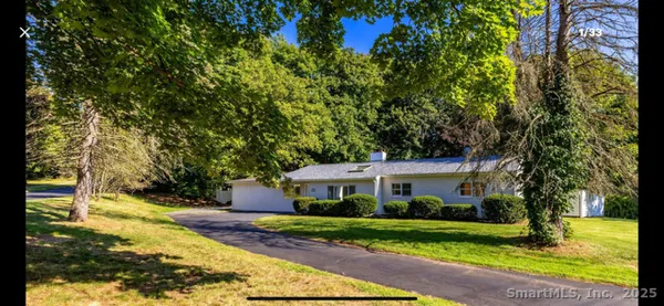 a front view of a house with a yard and trees