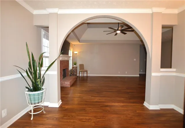 a view of a hallway with wooden floor and a bathroom