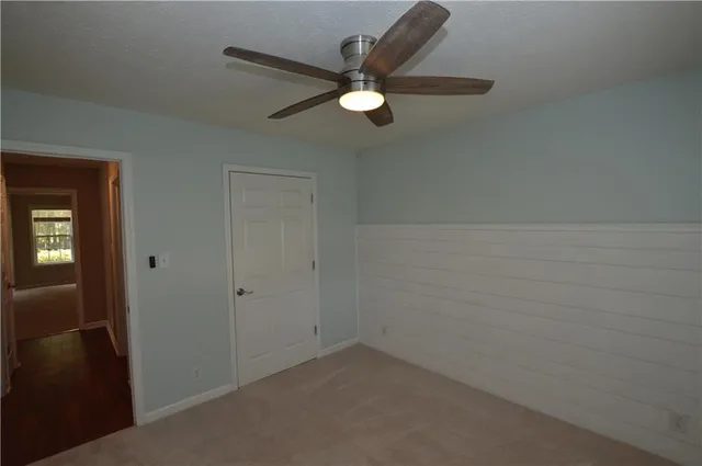 an empty room with wooden floor and mirror