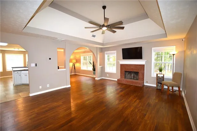 a view of a livingroom with furniture a fireplace wooden floor and chandelier