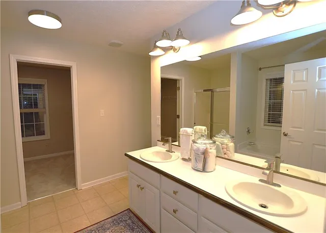 a bathroom with a granite countertop sink a mirror and a shower