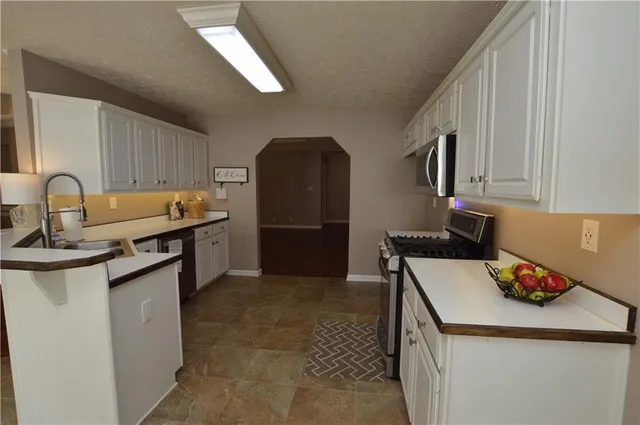 a kitchen with granite countertop a sink stove and cabinets