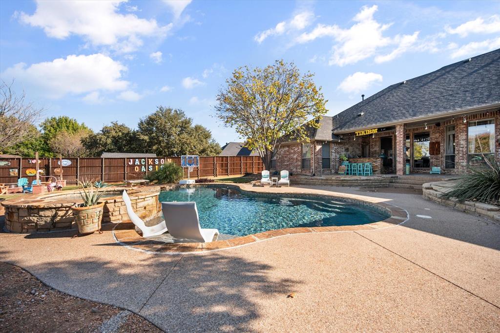View of pool with a patio, a water slide, and a fenced backyard