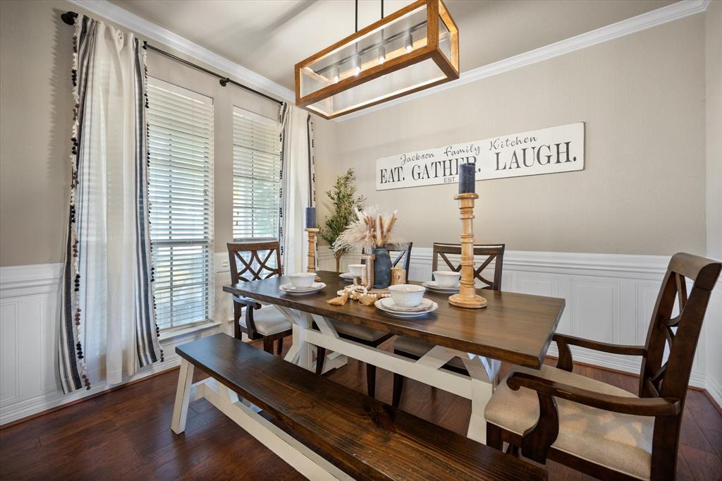 212 Ashmore Place Haslet, TX 76052 - Photo 17 of 39 Dining space with a decorative wall, a wainscoted wall, crown molding, and dark wood-style flooring