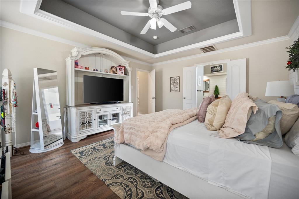 212 Ashmore Place Haslet, TX 76052 - Photo 20 of 39 Bedroom featuring a raised ceiling, ornamental molding, dark wood-style flooring, and ceiling fan