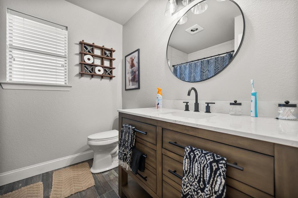 212 Ashmore Place Haslet, TX 76052 - Photo 25 of 39 Bathroom featuring a textured wall, vanity, dark wood-type flooring, and a shower with shower curtain