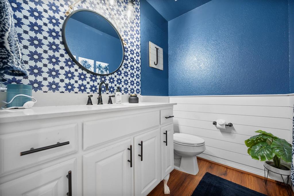212 Ashmore Place Haslet, TX 76052 - Photo 29 of 39 Half bathroom with vanity, dark wood-style flooring, a textured wall, and a wainscoted wall