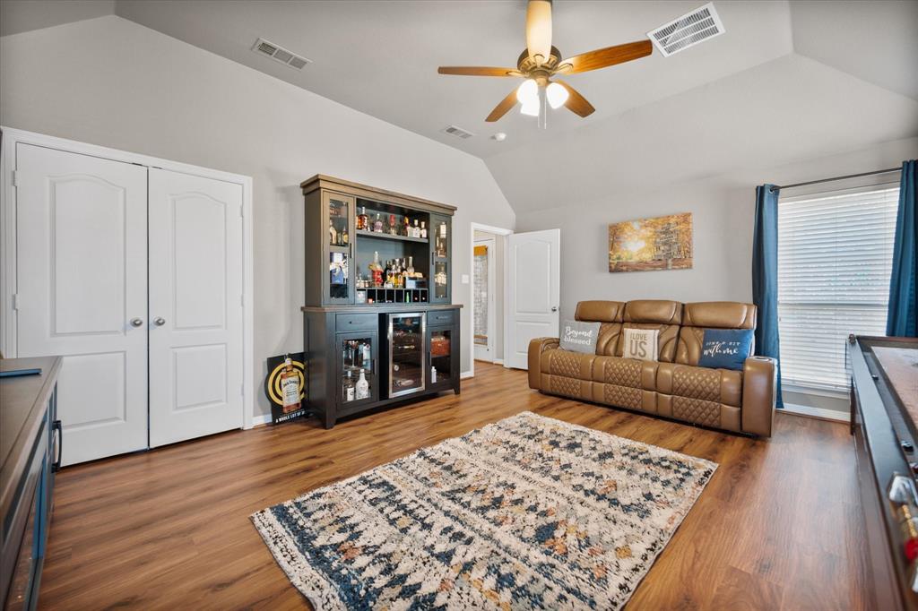 212 Ashmore Place Haslet, TX 76052 - Photo 31 of 39 Living room with a dry bar, vaulted ceiling, wood finished floors, and a ceiling fan