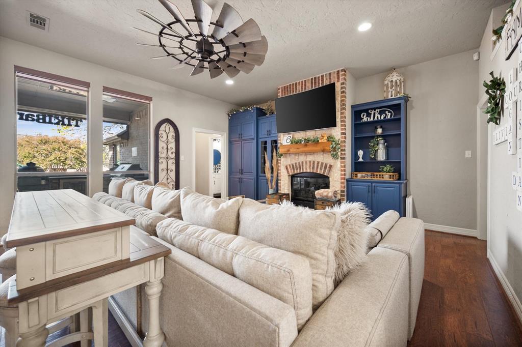 212 Ashmore Place Haslet, TX 76052 - Photo 7 of 39 Living area featuring a brick fireplace, recessed lighting, dark wood finished floors, a textured ceiling, and a ceiling fan