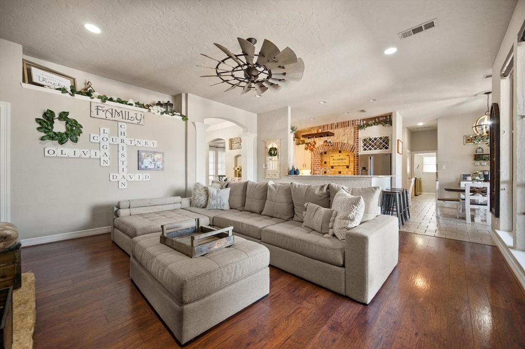 212 Ashmore Place Haslet, TX 76052 - Photo 9 of 39 Living room featuring arched walkways, recessed lighting, wood-type flooring, a textured ceiling, and decorative columns