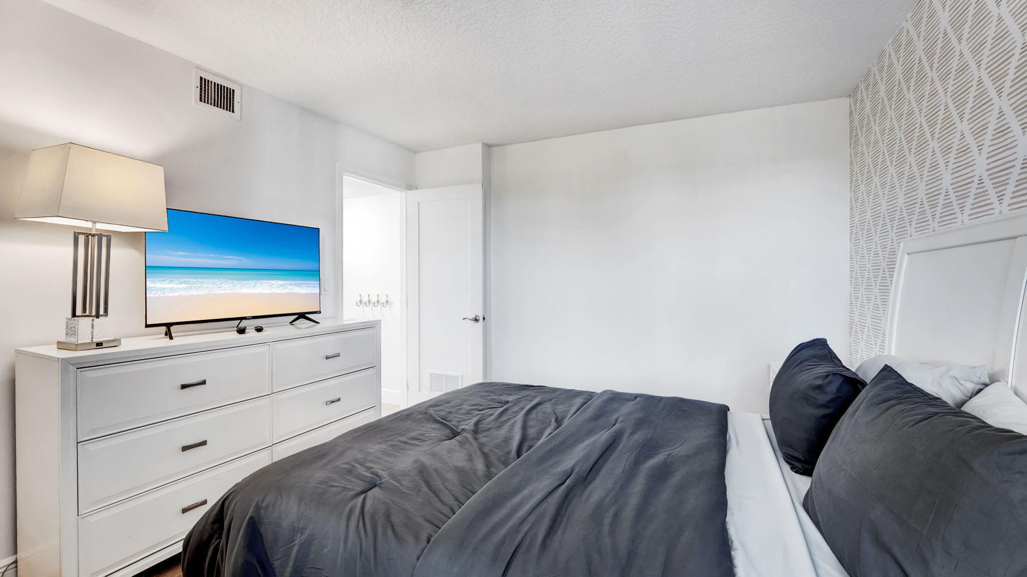 955 Dotterel Road, Unit 2103 Delray Beach, FL 33444 - Photo 12 of 23 a bedroom with a bed and a flat tv screen in it