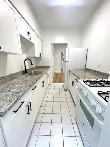 a kitchen with granite countertop a stove a sink and a granite counter tops