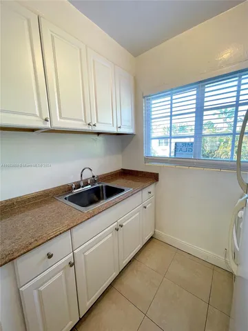 a kitchen with granite countertop white cabinets and sink