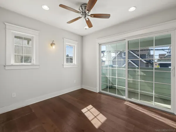 a view of a room with window a ceiling fan and wooden floor