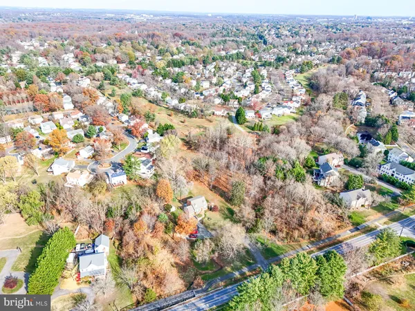 an aerial view of residential houses with outdoor space and trees