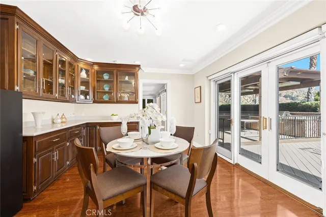 a dining room with furniture potted plants and wooden floor