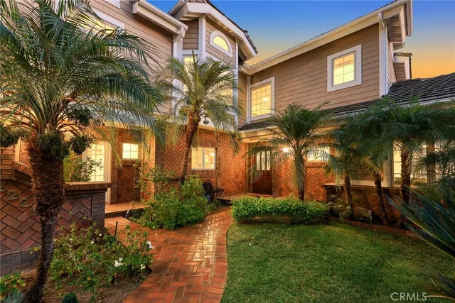a view of a house with a yard and palm trees
