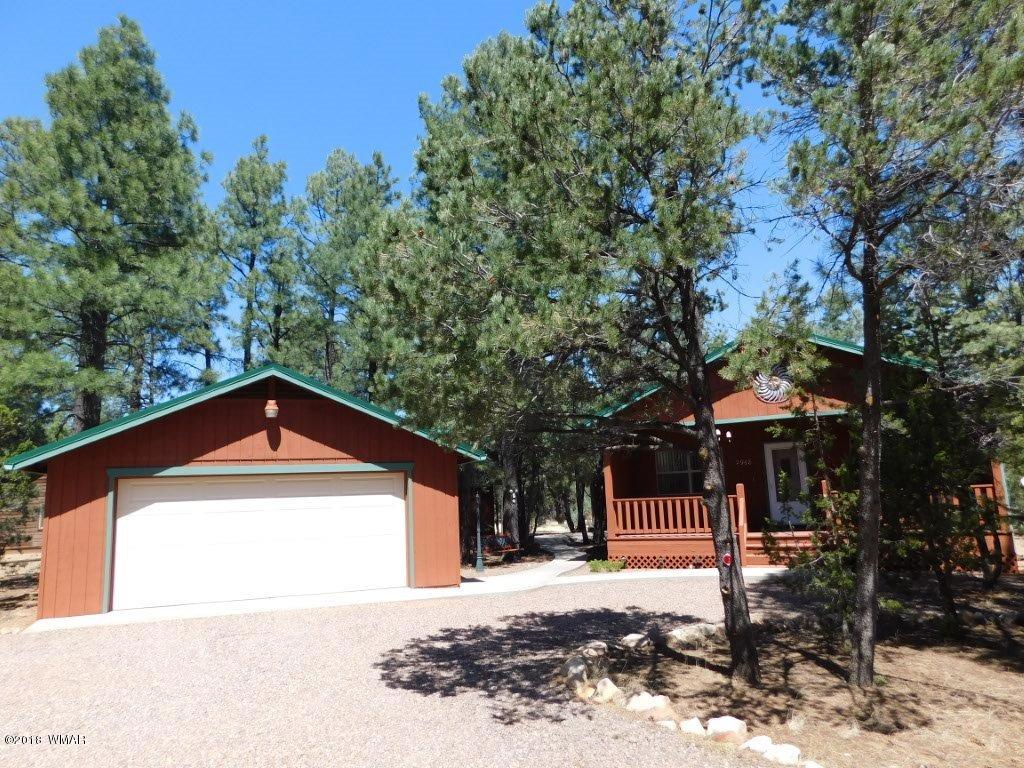 2968 Monica Road Overgaard, AZ 85933 - Photo 1 of 29 a front view of a house with a yard and garage