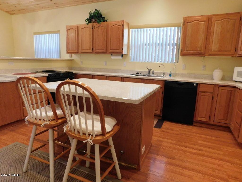 2968 Monica Road Overgaard, AZ 85933 - Photo 18 of 29 a kitchen with granite countertop a sink a counter space and cabinets