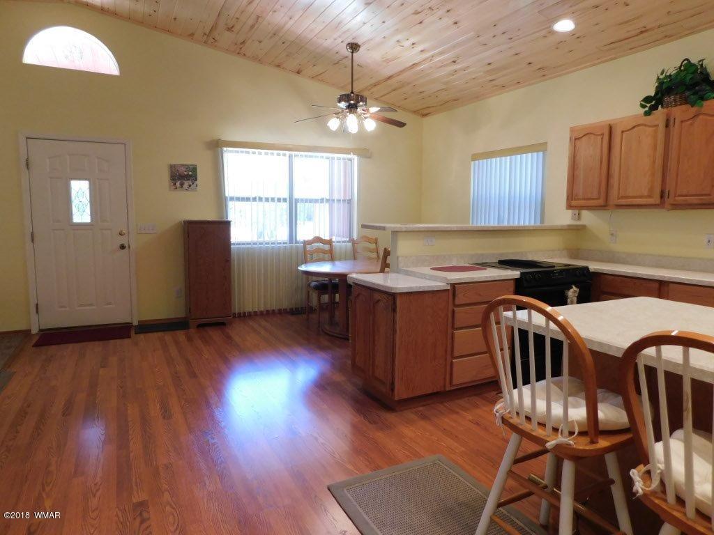 2968 Monica Road Overgaard, AZ 85933 - Photo 19 of 29 a kitchen that has a microwave a stove and wooden floor