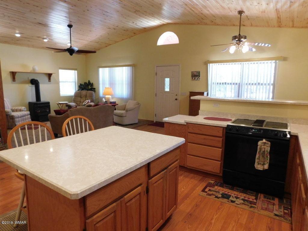 2968 Monica Road Overgaard, AZ 85933 - Photo 20 of 29 a kitchen with a stove a sink and a dining table