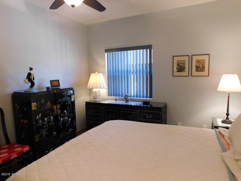 2968 Monica Road Overgaard, AZ 85933 - Photo 26 of 29 a bedroom with a bed and a lamp