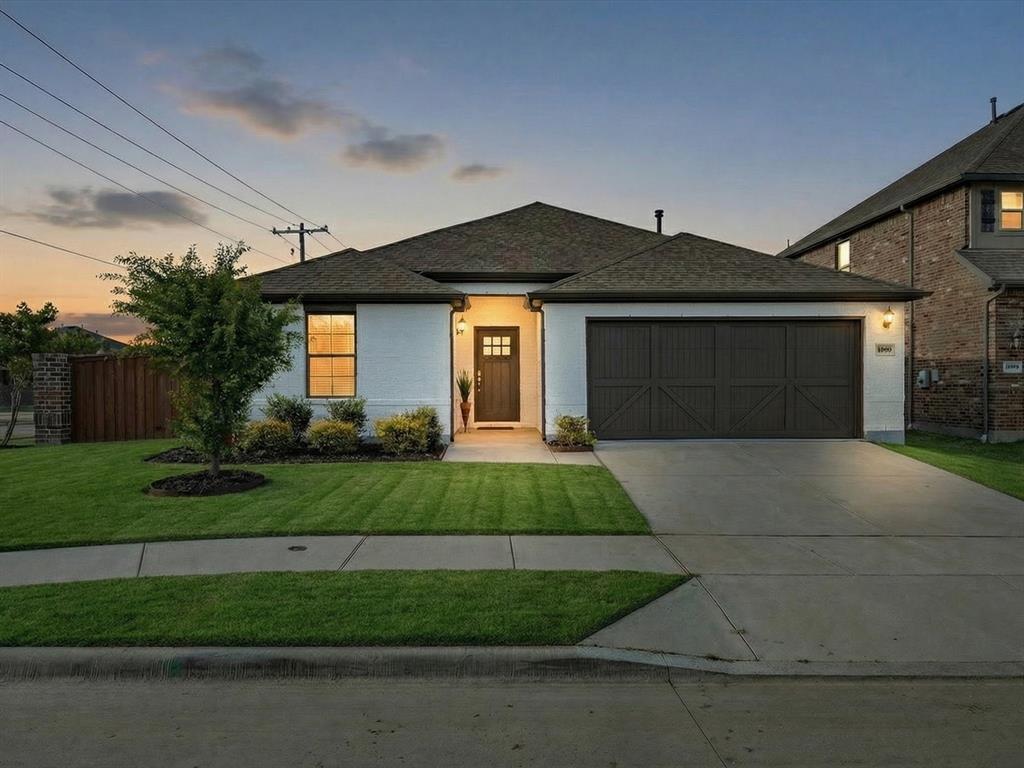View of front of home with an attached garage, a shingled roof, and concrete driveway