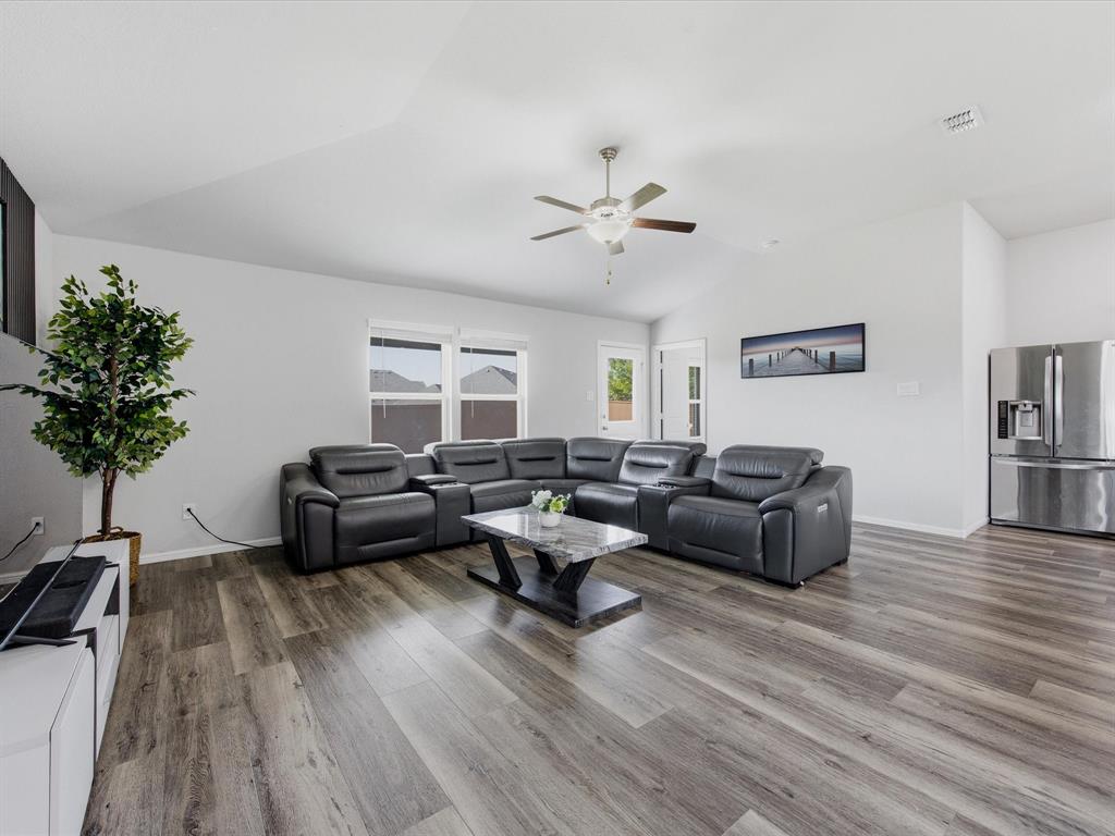 6000 Sutton Fields Trail Aubrey, TX 76227 - Photo 12 of 40 Living area with wood finished floors, lofted ceiling, and ceiling fan