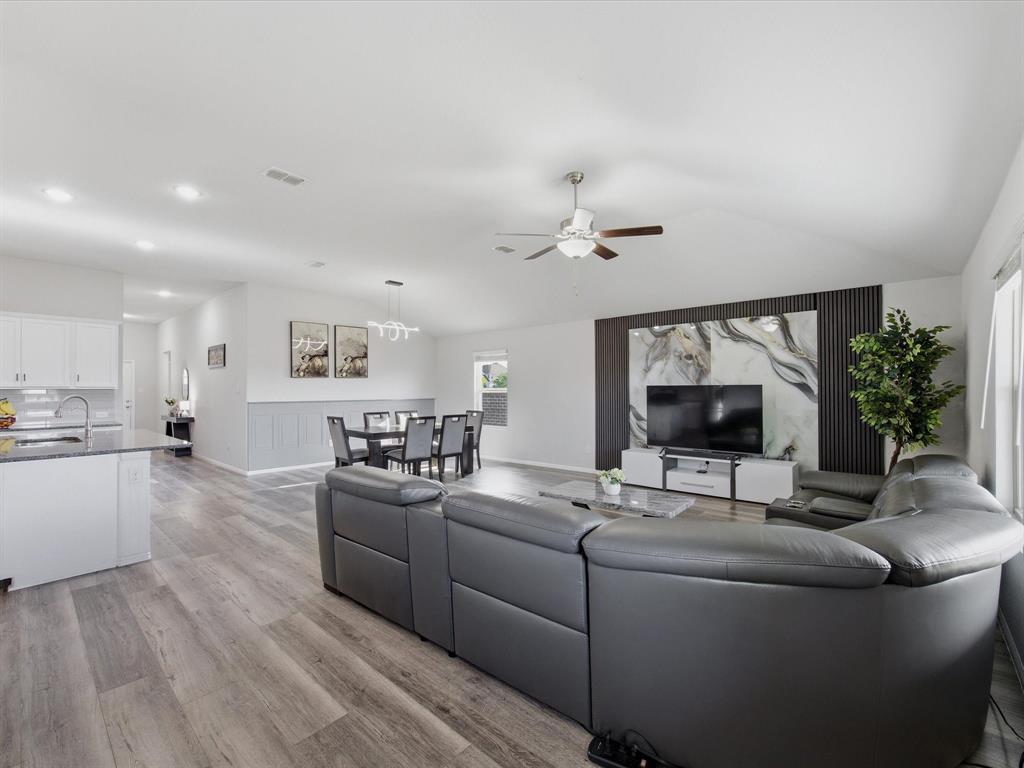 6000 Sutton Fields Trail Aubrey, TX 76227 - Photo 13 of 40 Living area featuring vaulted ceiling, light wood finished floors, a ceiling fan, and recessed lighting