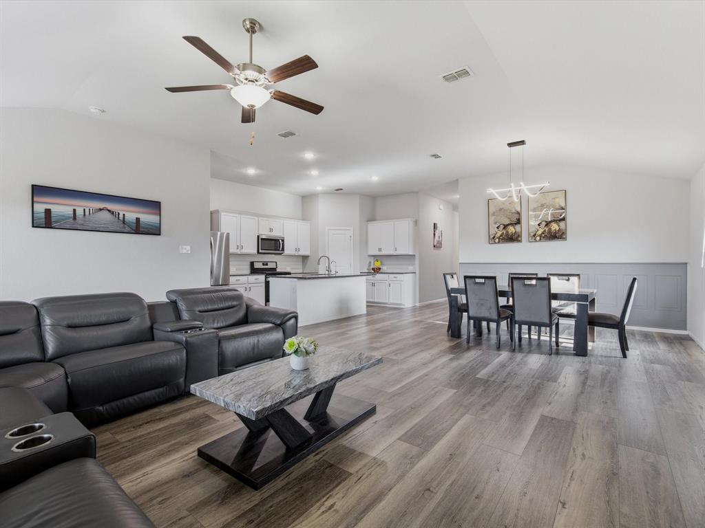6000 Sutton Fields Trail Aubrey, TX 76227 - Photo 14 of 40 Living room featuring vaulted ceiling, dark wood-style flooring, ceiling fan, and a chandelier