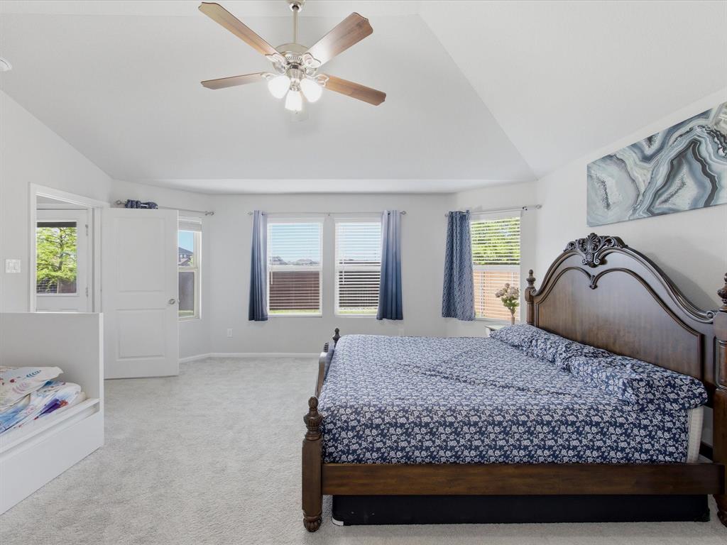 6000 Sutton Fields Trail Aubrey, TX 76227 - Photo 17 of 40 Primary Bedroom with light carpet, lofted ceiling, and ceiling fan