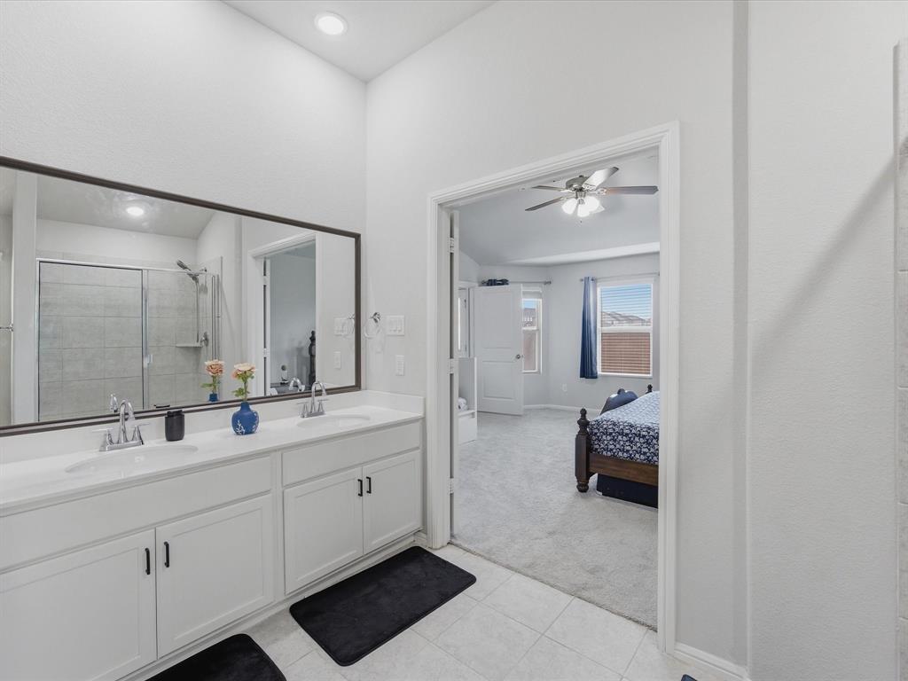 6000 Sutton Fields Trail Aubrey, TX 76227 - Photo 19 of 40 Primary bath with double vanity, light carpet, ensuite bath, a stall shower, and ceiling fan