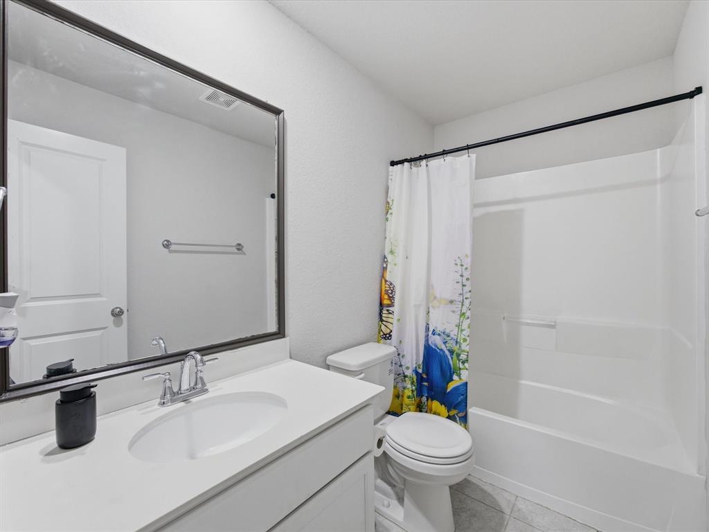 6000 Sutton Fields Trail Aubrey, TX 76227 - Photo 24 of 40 Bathroom featuring vanity, shower / tub combo with curtain, and light tile patterned floors