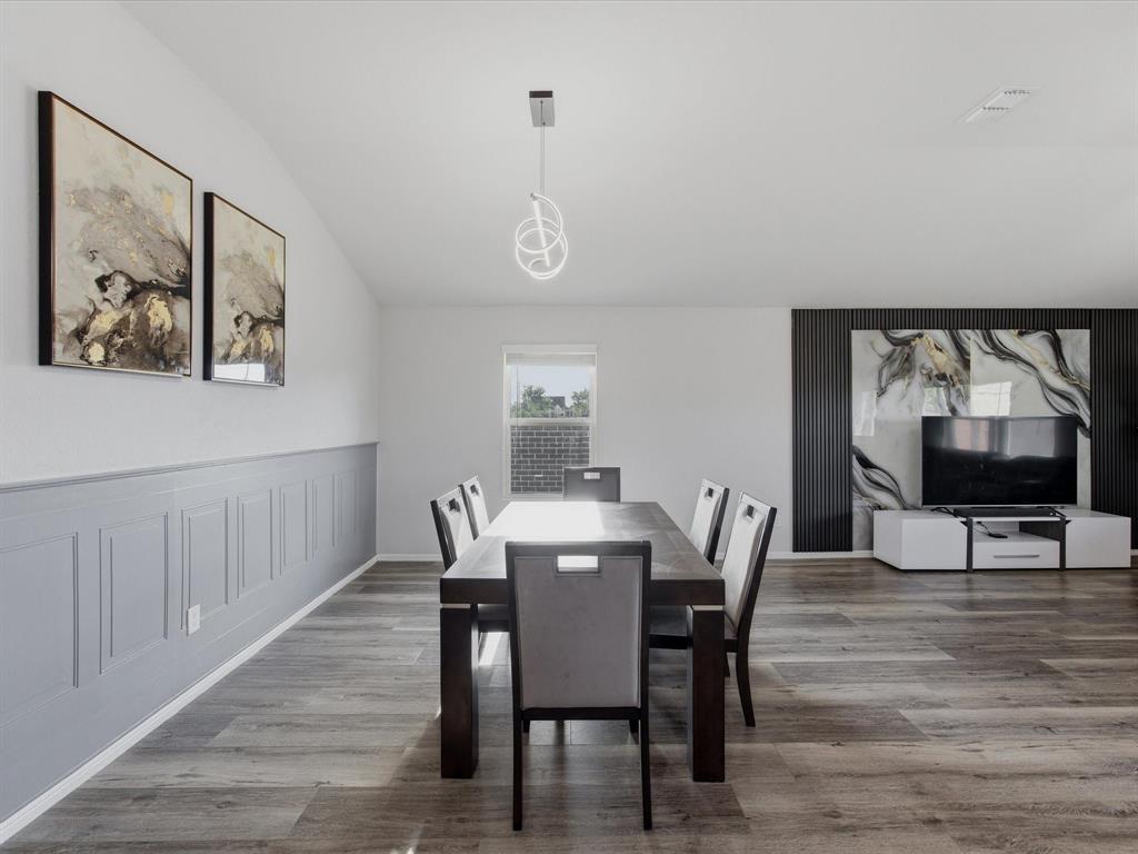 6000 Sutton Fields Trail Aubrey, TX 76227 - Photo 4 of 40 Dining space featuring lofted ceiling, light wood-style flooring, wainscoting, and a decorative wall