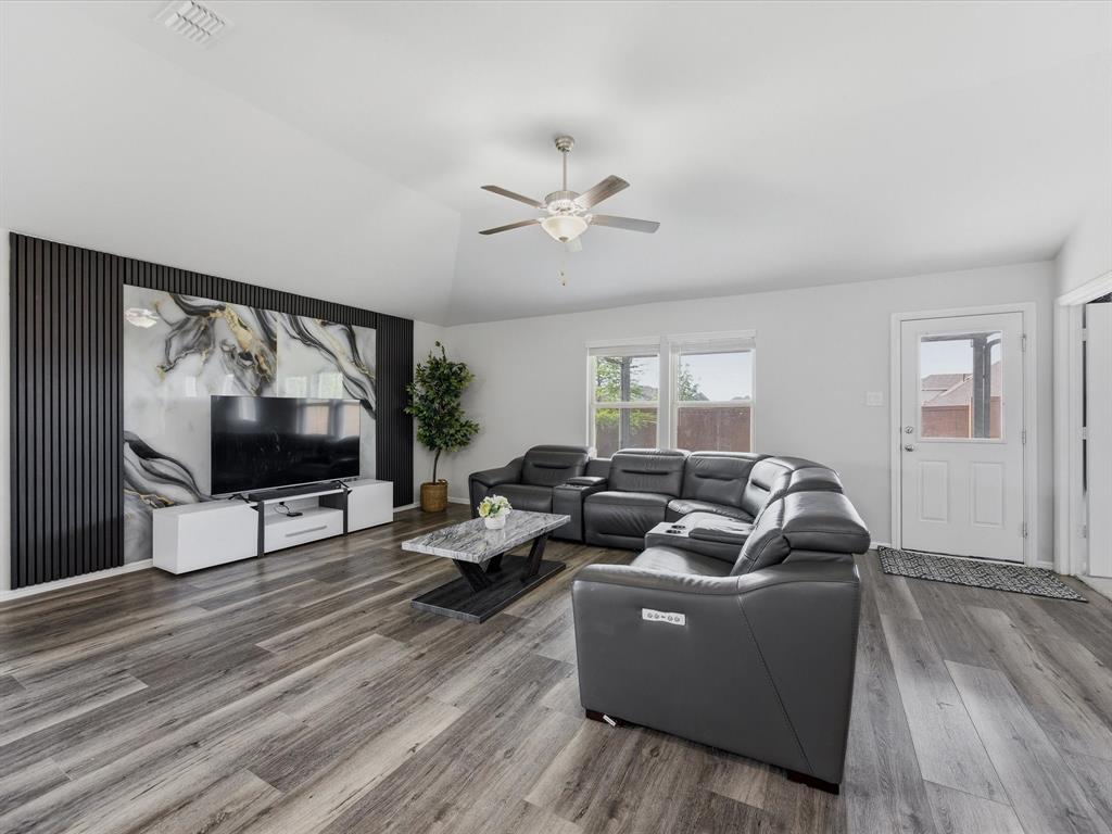 6000 Sutton Fields Trail Aubrey, TX 76227 - Photo 7 of 40 Living area with wood finished floors, ceiling fan, and vaulted ceiling