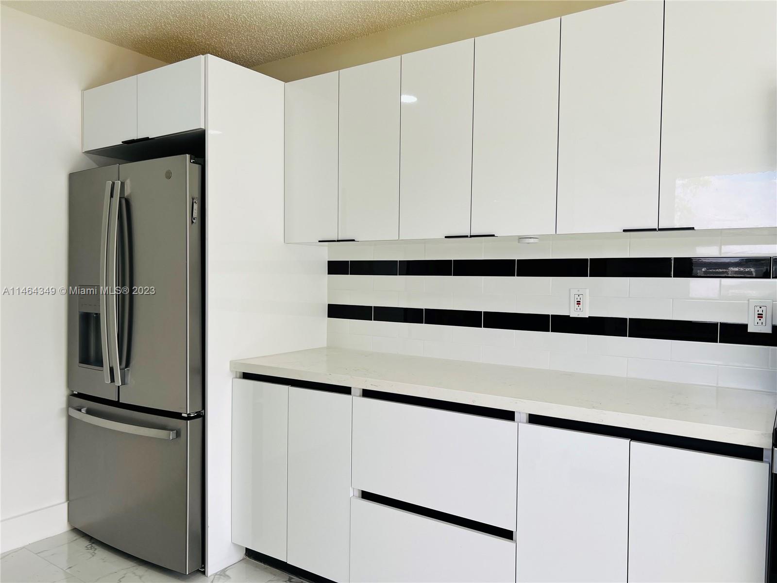 11301 Southwest 203rd Terrace Miami, FL 33189 - Photo 14 of 51 a kitchen with stainless steel appliances white cabinets and a refrigerator