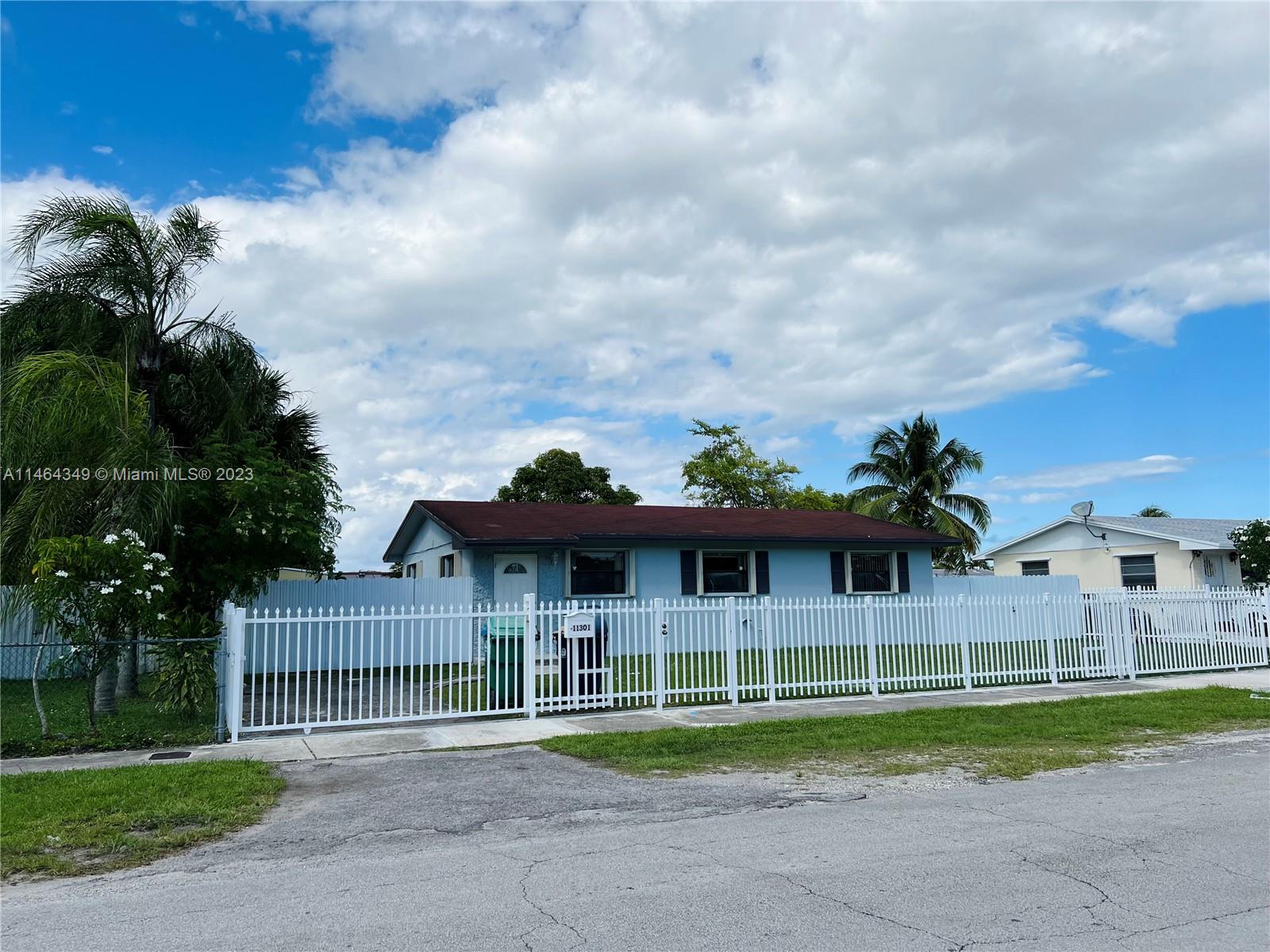11301 Southwest 203rd Terrace Miami, FL 33189 - Photo 2 of 51 a front view of house with yard and green space