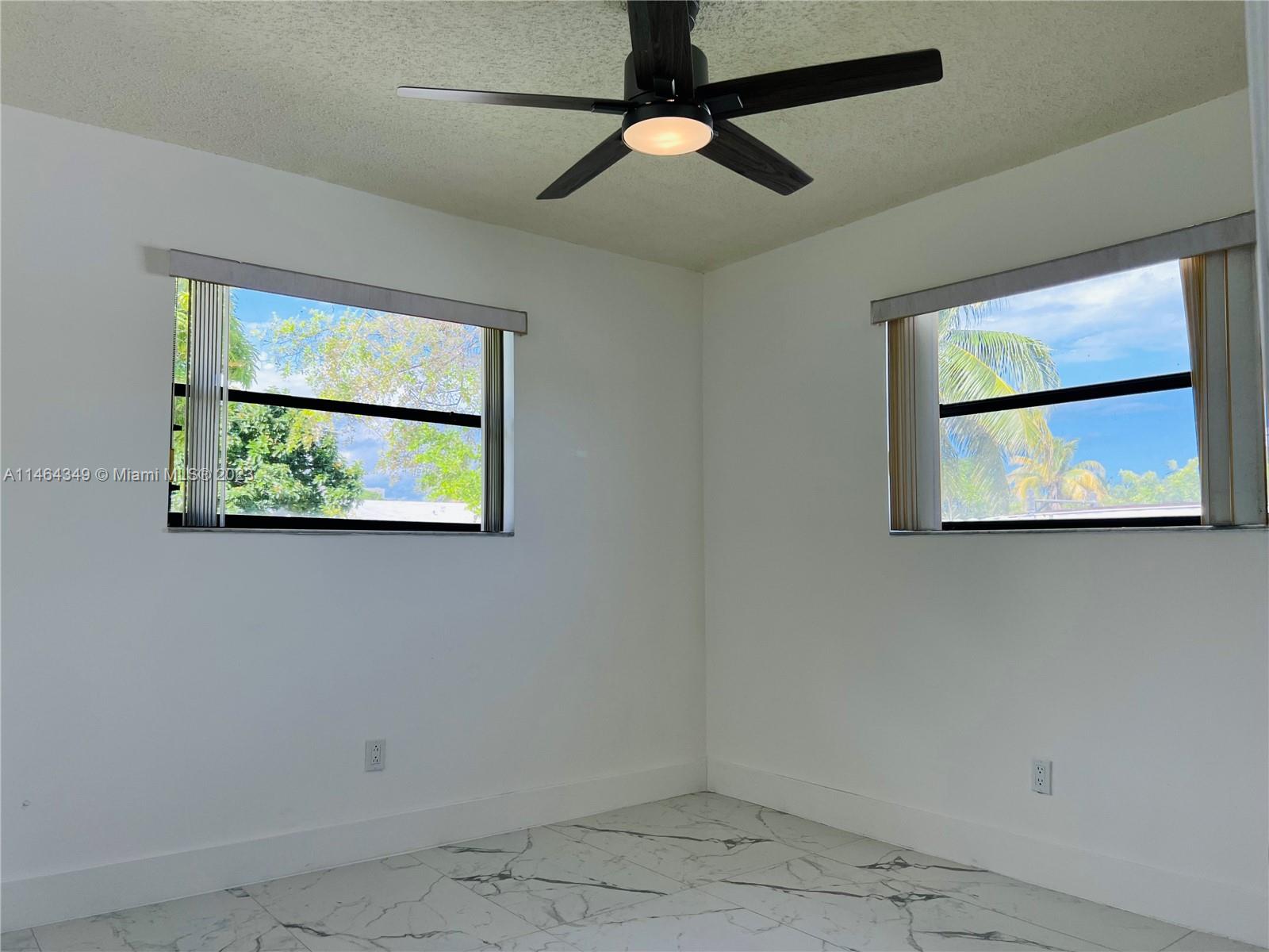 11301 Southwest 203rd Terrace Miami, FL 33189 - Photo 23 of 51 an empty room with wooden floor and windows