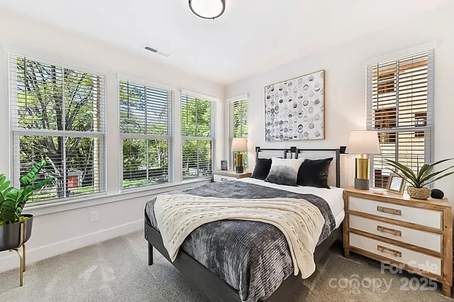 a bed sitting in a bedroom next to a window