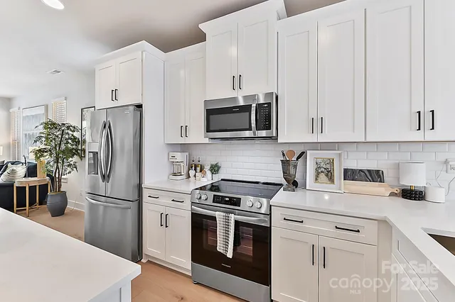 a kitchen with stainless steel appliances white cabinets and a stove