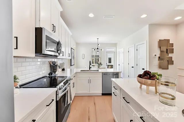 a kitchen with stainless steel appliances a sink stove top oven and cabinets