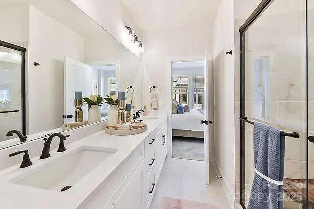 a en suite bathroom with double sink a mirror and a shower
