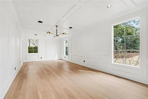 a view of an empty room with wooden floor fireplace and a window