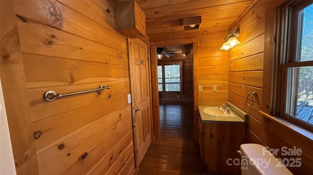 a view of a hallway with wooden floors and a window