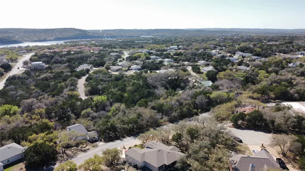 an aerial view of residential houses with outdoor space and trees