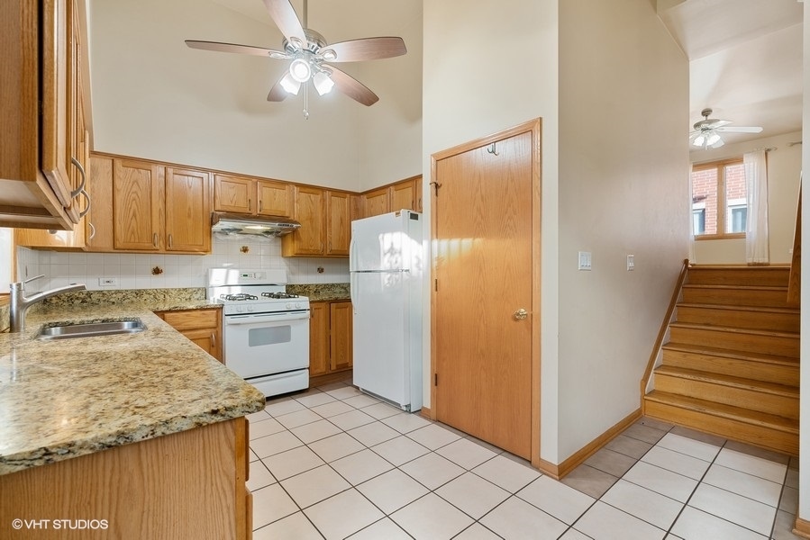 2815 South Farrell Street, Unit A Chicago, IL 60608 - Photo 7 of 18 a kitchen with granite countertop a refrigerator a sink and dishwasher