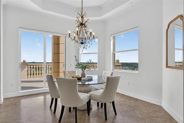 a spacious bedroom with a bed a couch and a chandelier
